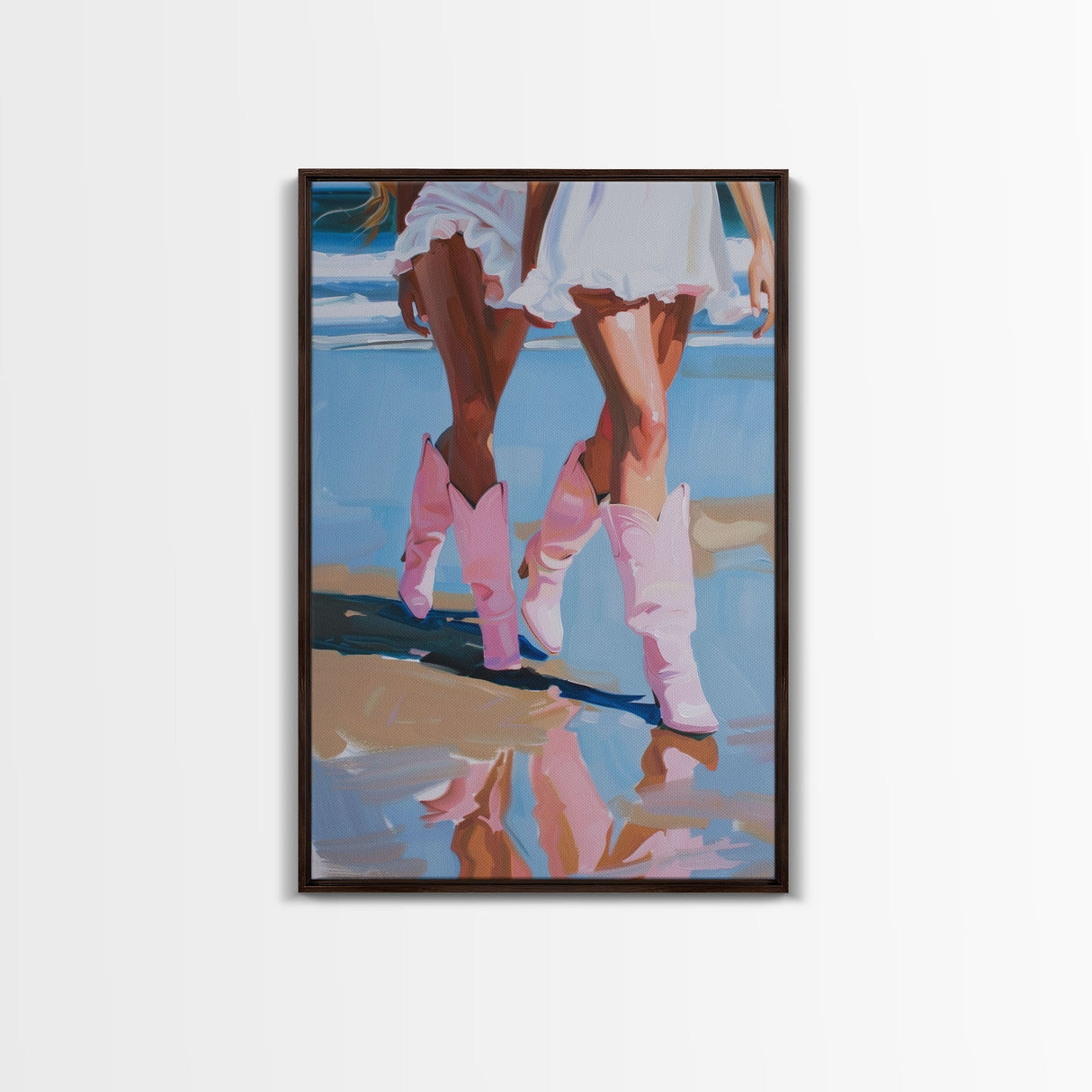 Two women wearing pink cowboy boots walking on the beach, reflections in sand Framed Canvas Print - beach decor, fashion art, summer vibes