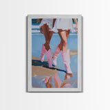 Two women wearing pink cowboy boots walking on the beach, reflections in sand Framed Canvas Print - beach decor, fashion art, summer vibes