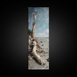 Framed Canvas Print Skinny Art of a Weathered Driftwood Tree Trunk on a Sandy Shore with a Calm Ocean Backdrop, Ideal Tall Art for Coastal Decor