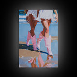 Two women wearing pink cowboy boots walking on the beach, reflections in sand Framed Canvas Print - beach decor, fashion art, summer vibes