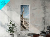 Framed Canvas Print Skinny Art of a Weathered Driftwood Tree Trunk on a Sandy Shore with a Calm Ocean Backdrop, Ideal Tall Art for Coastal Decor